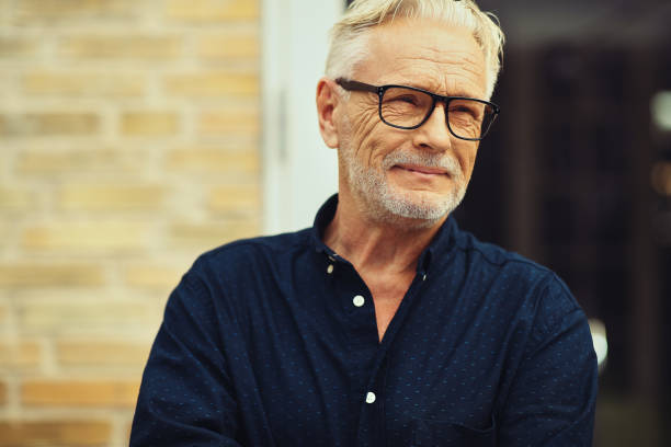 istock Smiling senior man standing in his yard deep in thought 961408612