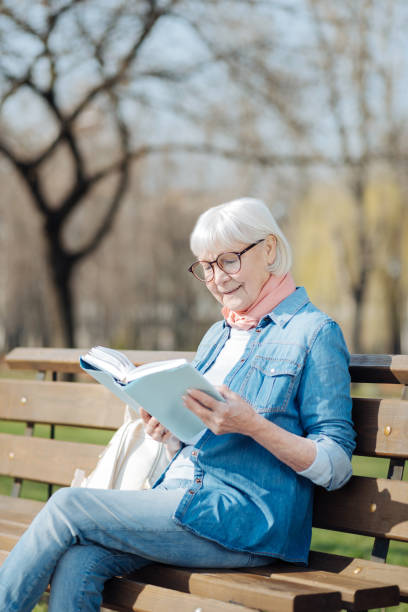 istock Delighted old woman reading a book 961410550