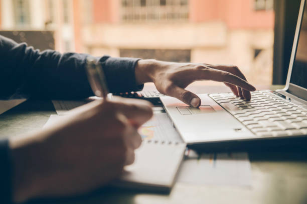 istock Close up hands man doing finances with using laptop and writing note at home office 961410710