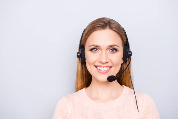 close up portrait of cheerful smart clever confident focused pretty responsive expert experienced charming operator with toothy smile using headphones isolated on gray background - speech recruitment technology young adult imagens e fotografias de stock