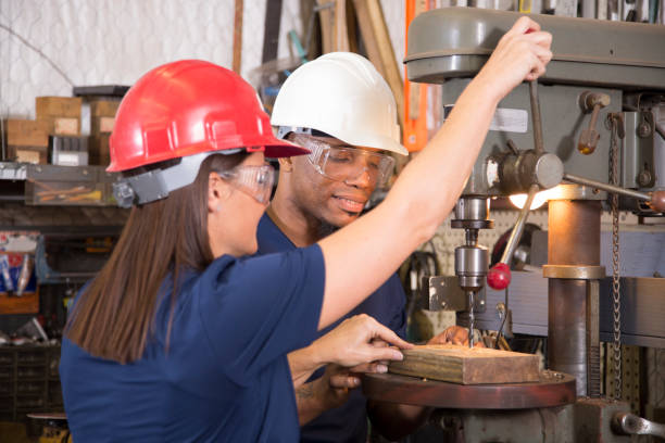 istock Industrial workers use drill press equipment together in factory. 961419468
