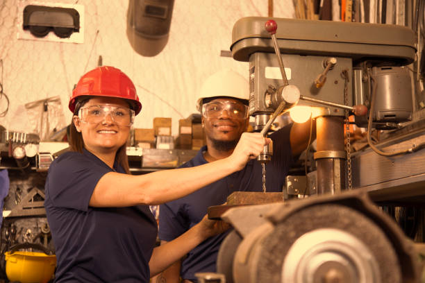 istock Industrial workers use drill press equipment together in factory. 961420452