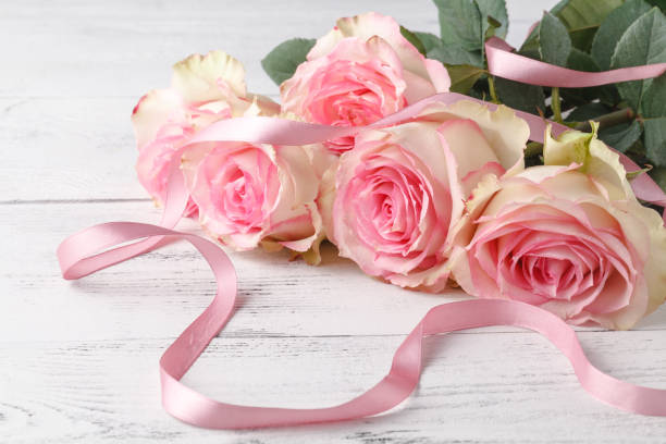 istock Pink roses on the wooden table, selective focus 961426352