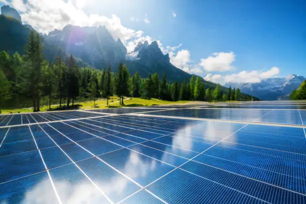 Solar cell panel in country landscape against sunny sky and mountain backgrounds. Solar power is the innovation for sustainability of world energy. Sustainable resources.