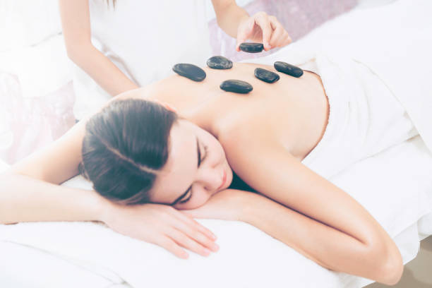 istock Hot stone massage treatment by therapist in spa. 961427230