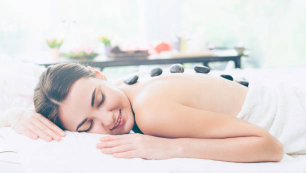 istock Hot stone massage treatment by therapist in spa. 961427394