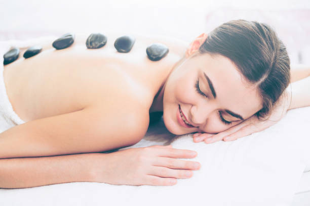 istock Hot stone massage treatment by therapist in spa. 961427402