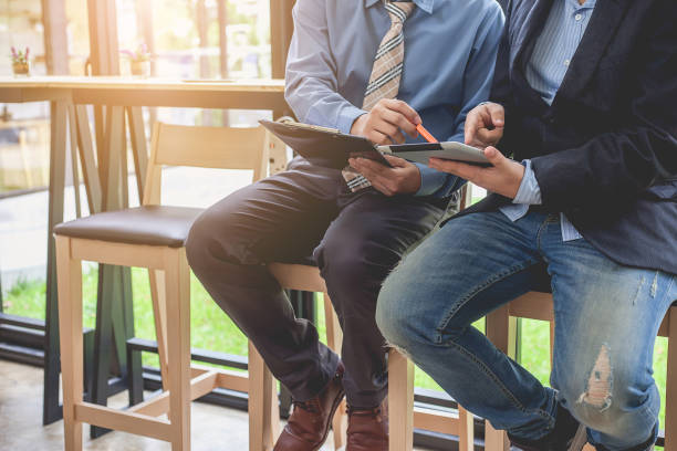 Two businessman sitting together in a coffee shop.