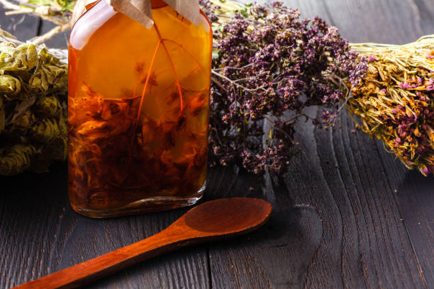 istock Herb-flavored oil on dark wooden table 961443312