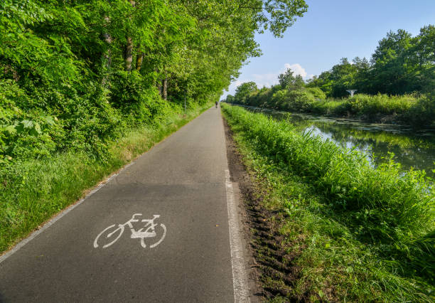 Empty cycling path along the Naviglio Pavese, canal which stretches for 30km from Pavia to Milan, Italy. stock photo