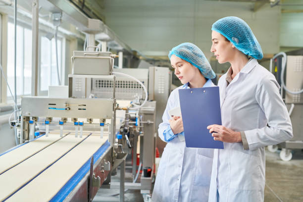 istock Concentrated food factory technologist observing cutting dough by machine and estimating quality of equipment at plant shop 961452964