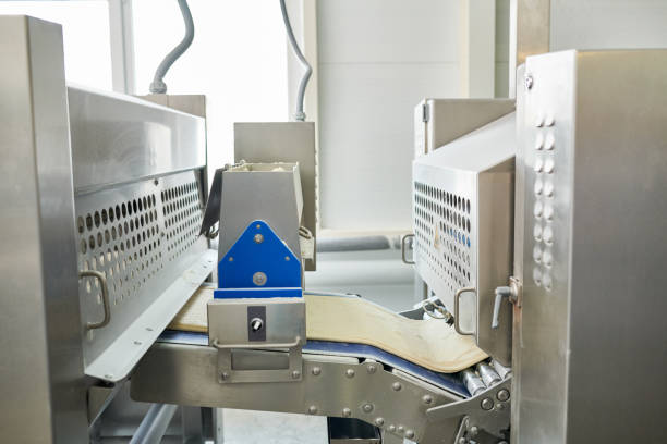istock Close-up of conveyor belt with flat dough row between two industrial machine for kneading 961453728
