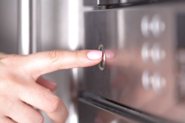 istock Woman Using Microwave Oven For Baking Fresh Cookies In Kitchen 961454198