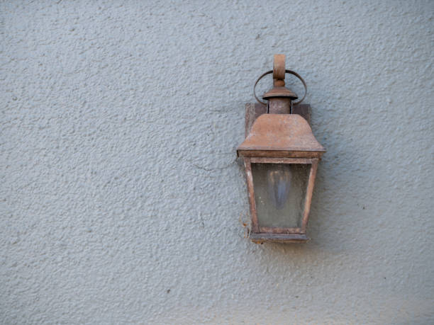 istock Rustic copper lamp attached outside a house on white wall 961454542