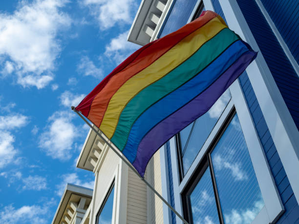 día del orgullo gay, bandera lgbt entrega fuera de una casa - parade of homes fotografías e imágenes de stock