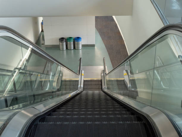 escada rolante descendo em um terminal de aeroporto vazio - escalator automated built structure moving down - fotografias e filmes do acervo