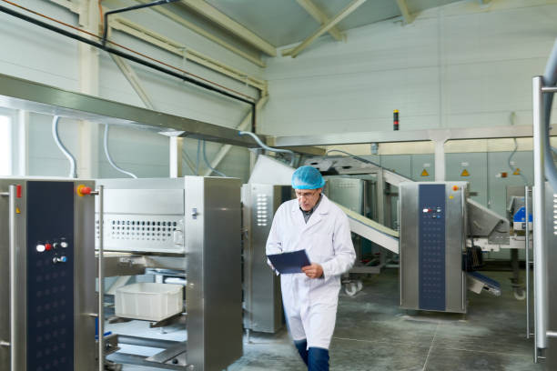 istock Serious concentrated inspector in sterile clothes analyzing data while hurrying to other factory shop in food plant 961457822