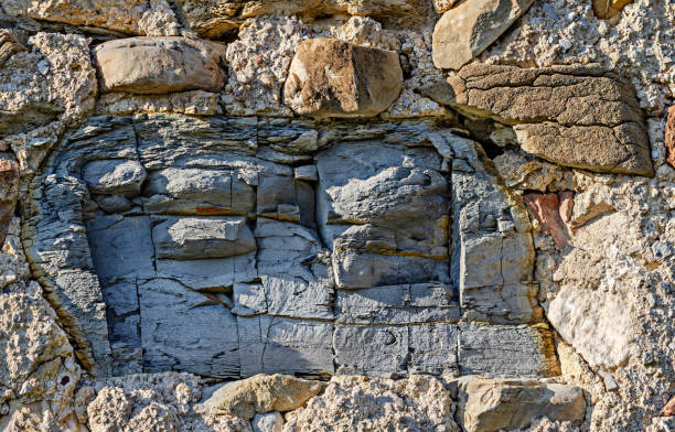 grande pezzo di ardesia incrinato in un vecchio muro di pietra - foliated foto e immagini stock