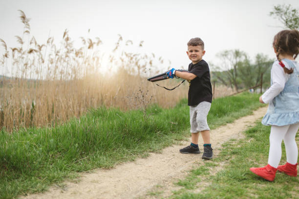 istock Siblings shooting from a toy gun 961471090
