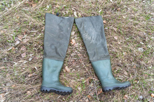 istock Boots for fishing on dry grass 961475668