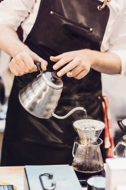 istock Young men barista at work in a cafe. Preparing pour over coffee 961476784