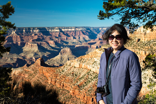 Mature asian woman enjoying the view on the south rim of the Grand Canyon