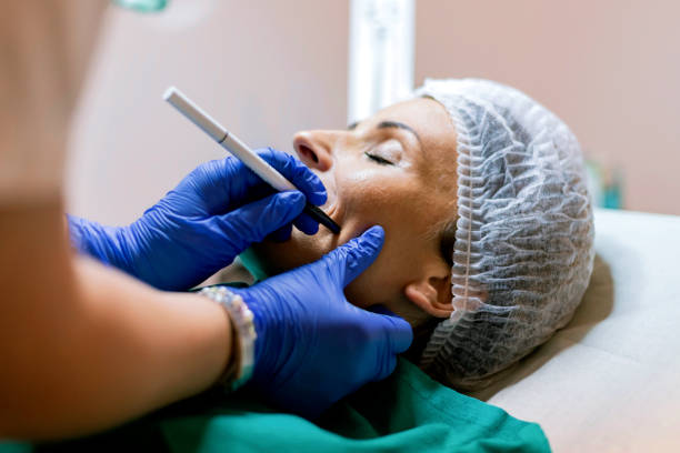 istock Beautician touch and draw correction lines on woman face 961482594