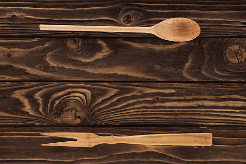 elevated view of wooden fork for meat and spoon on table