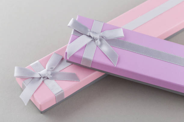 istock Pink and violet gift boxes with bows on gray background 961495838