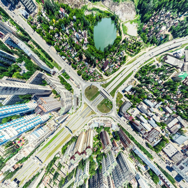 Aerial city view with crossroads and roads, houses, buildings, parks and parking lots. Sunny summer panoramic image - fotografia de stock