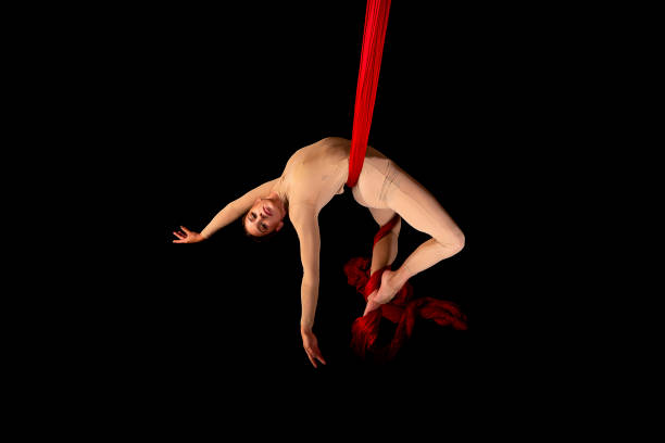 mujer joven realizando acrobacias en sedas - acróbata circo fotografías e imágenes de stock