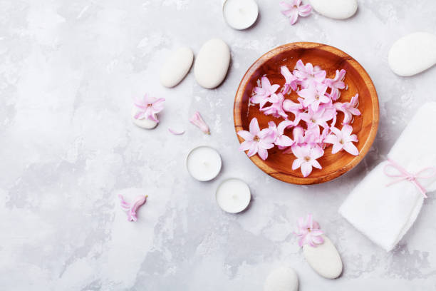 istock Aromatherapy, spa, beauty background with massage pebble, perfumed flowers water and candles on stone table from above for relaxation. Flat lay style. 961506030