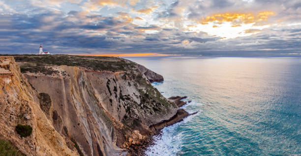 The Espichel Cape, with the 18th century lighthouse The Espichel Cape, with the 18th century lighthouse and a view over the Atlantic Ocean during sunset. Sesimbra, Portugal. headland stock pictures, royalty-free photos & images