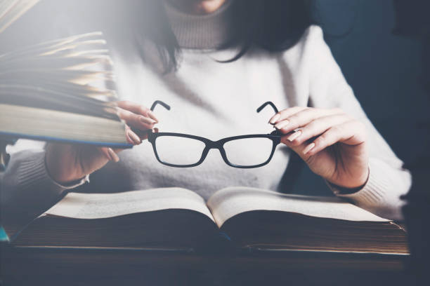 istock Woman reading a book and hand eyeglasses 961507774
