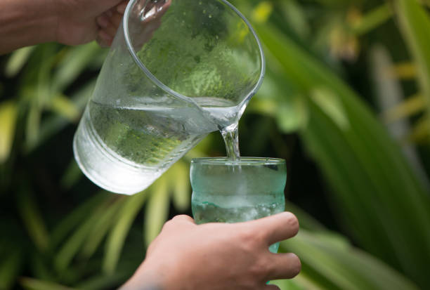 istock Pouring drinking water in the green glass. 961507778