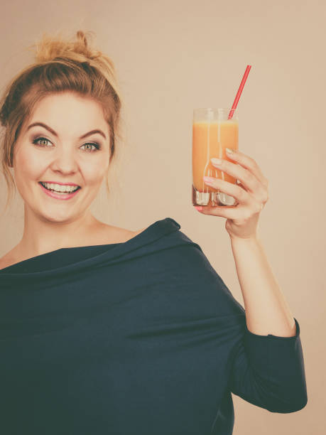 istock Happy woman holding fresh orange juice 961508076