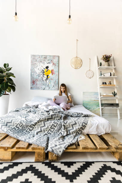 istock focused young woman using laptop while resting in bed in morning at home 961508148