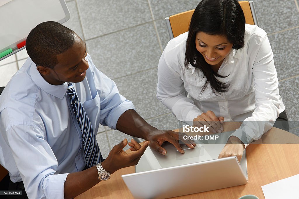 Nero Business mentor in collaborazione con client su computer portatile in ufficio - Foto stock royalty-free di Corso di formazione