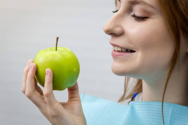 istock Young woman with healthy tooth biting green apple 961510504