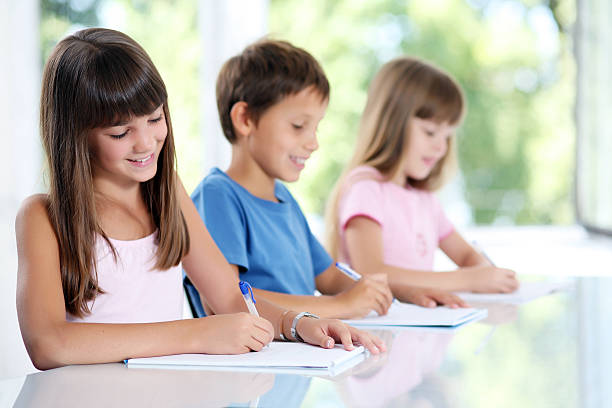 tres de los escolares aprendizaje en montaje tipo aula. - schoolgirl little girls crayon human face fotografías e imágenes de stock