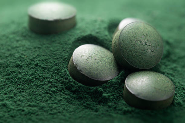 Close up of Atisanal Spirulina Tablets and Powder Close up of Atisanal Spirulina Tablets on Powder Background With Low Depth of Field. Horizontal Image spirulina bacterium stock pictures, royalty-free photos & images
