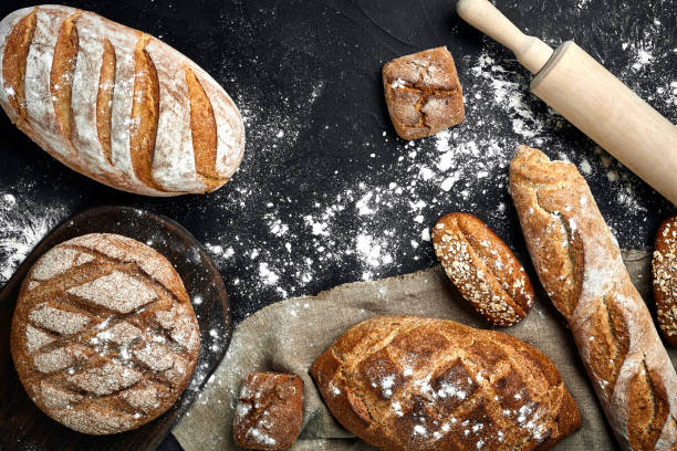 istock Different bread with ears on wooden background 961510968
