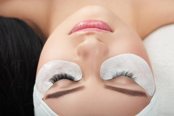 istock Photo comparison of woman's normal and enlarged lashes. 961512096