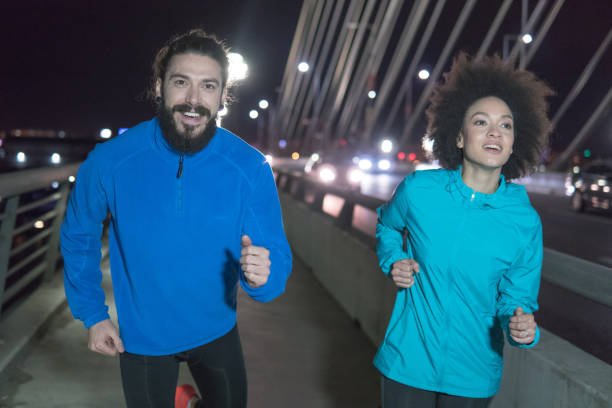 istock Couple exercising outdoors at night and smiling 961516472