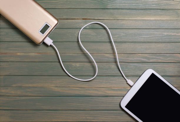 istock Portable power bank and tablet PC on wooden background 961516876