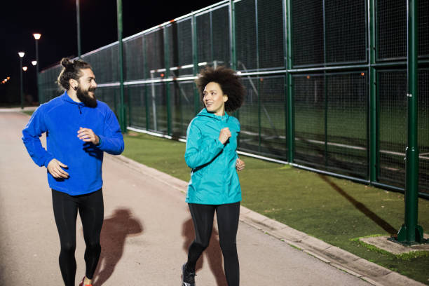 istock Young couple jogging outdoors at night 961517196