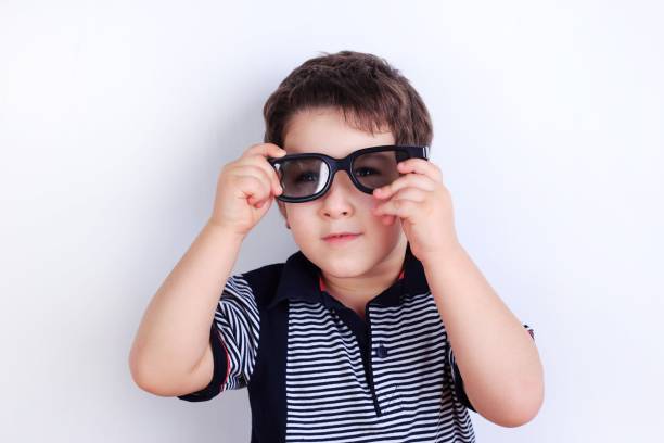 funny photo of cute little boy putting on sunglasses, studio sho - studio sho imagens e fotografias de stock