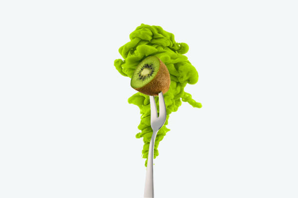 half of kiwi on fork and green ink isolated on white