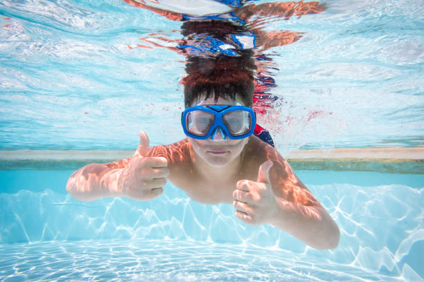 istock Boy in mask dive in swimming pool 961523604