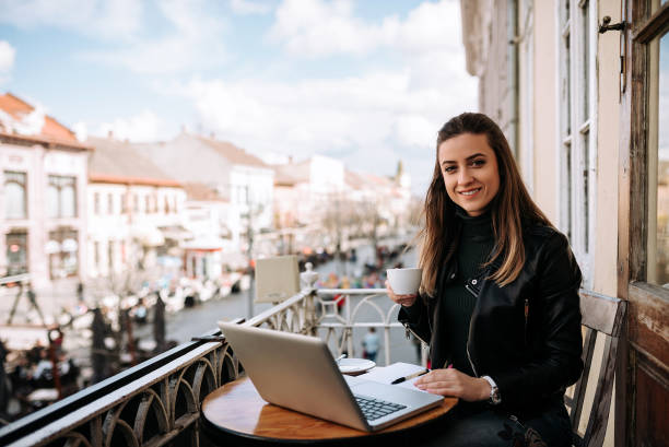 istock Cute female jounalist working outdoors at the cafe. Looking at camera. 961523652
